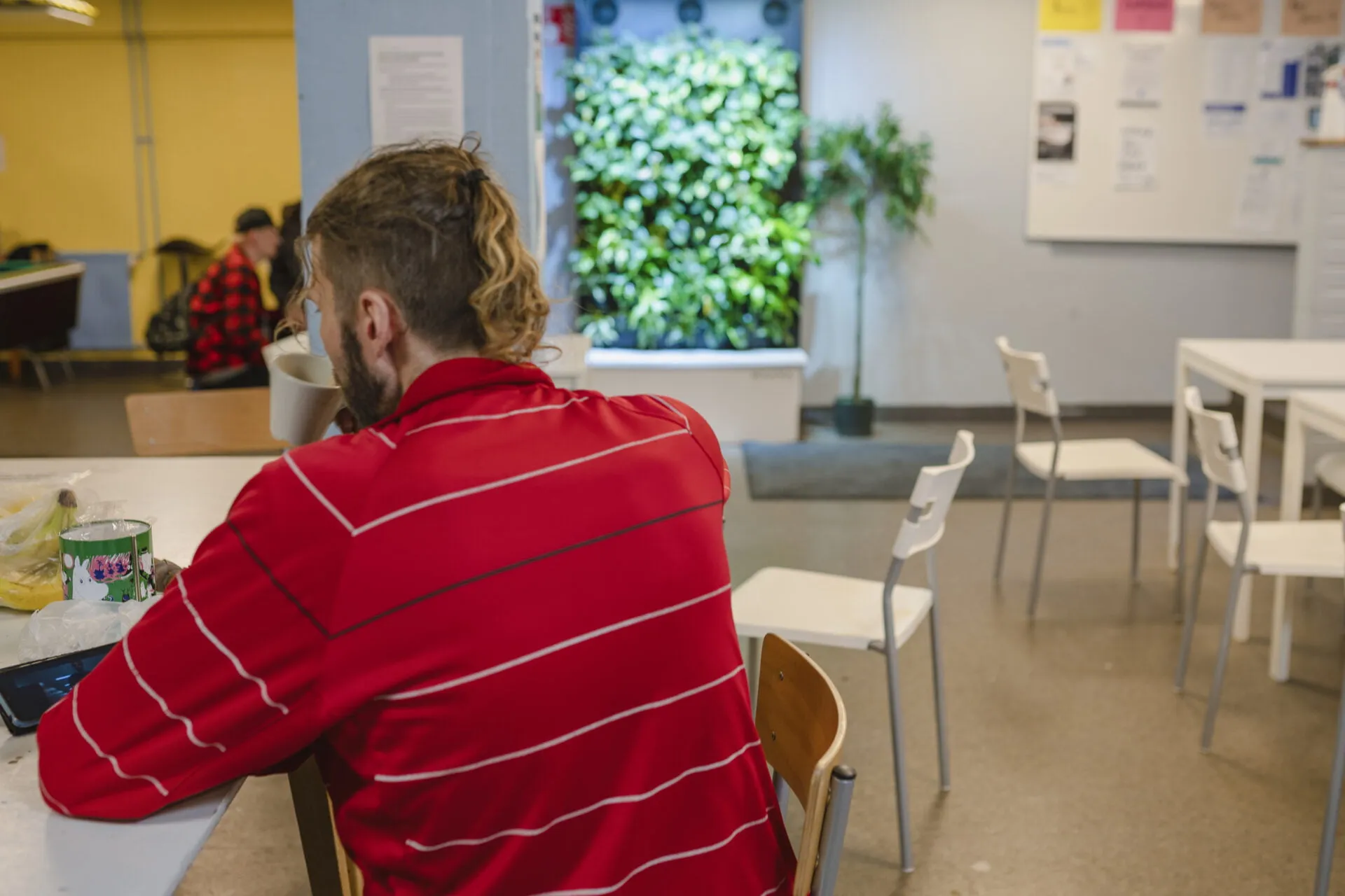 Henkilö istuu muki kädessä Cafe Illusian pöydän ääressä