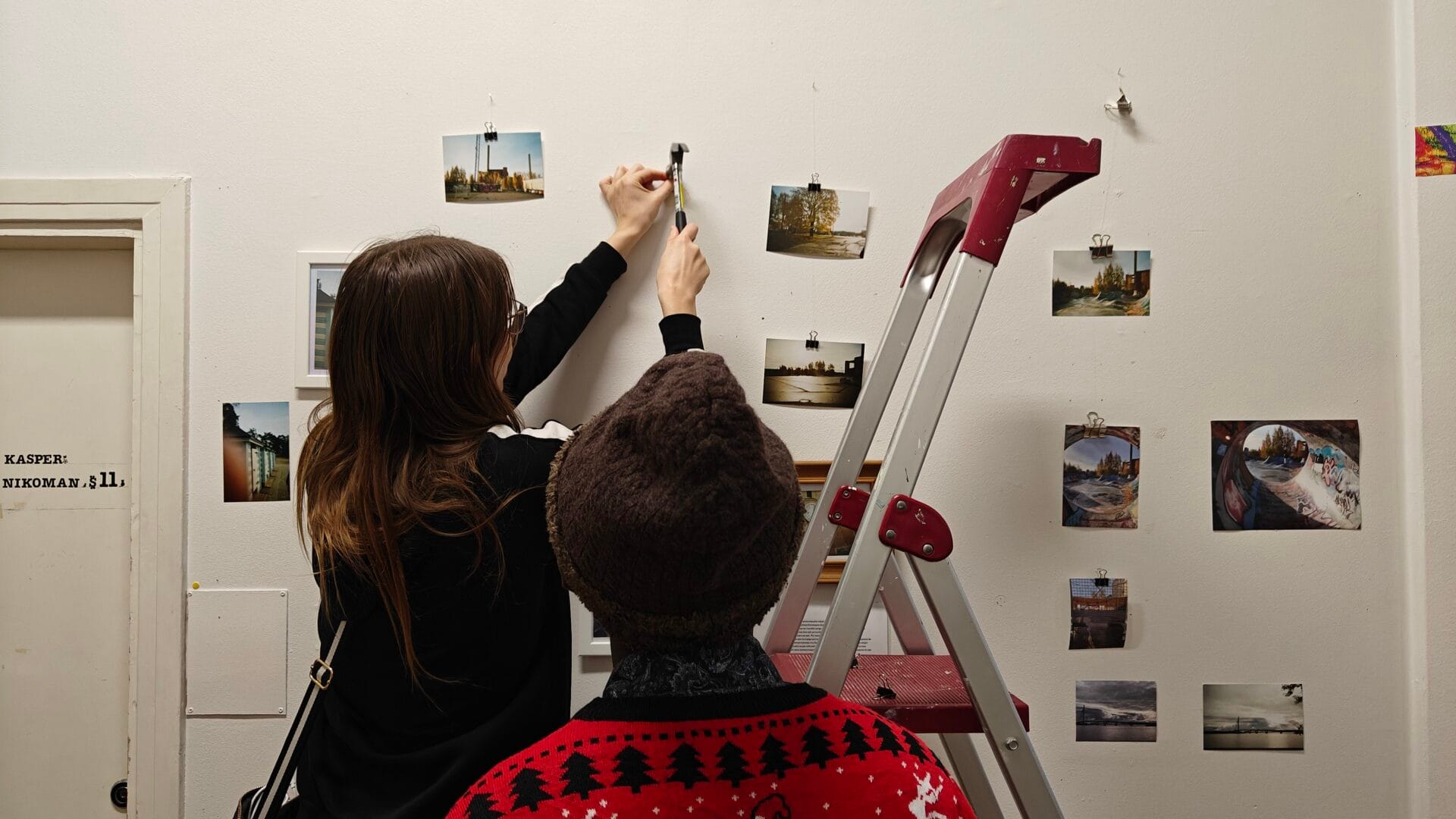 Bringing Us Together -valokuvanäyttelyn töiden asettelua seinälle.